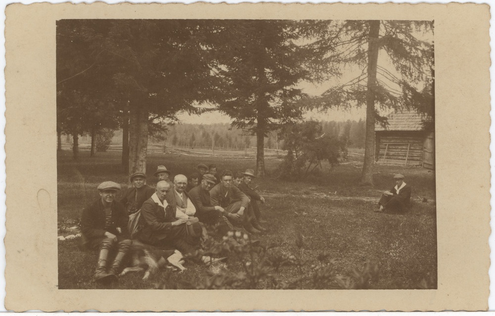 Seltskond mehi puude all taluhoone juures