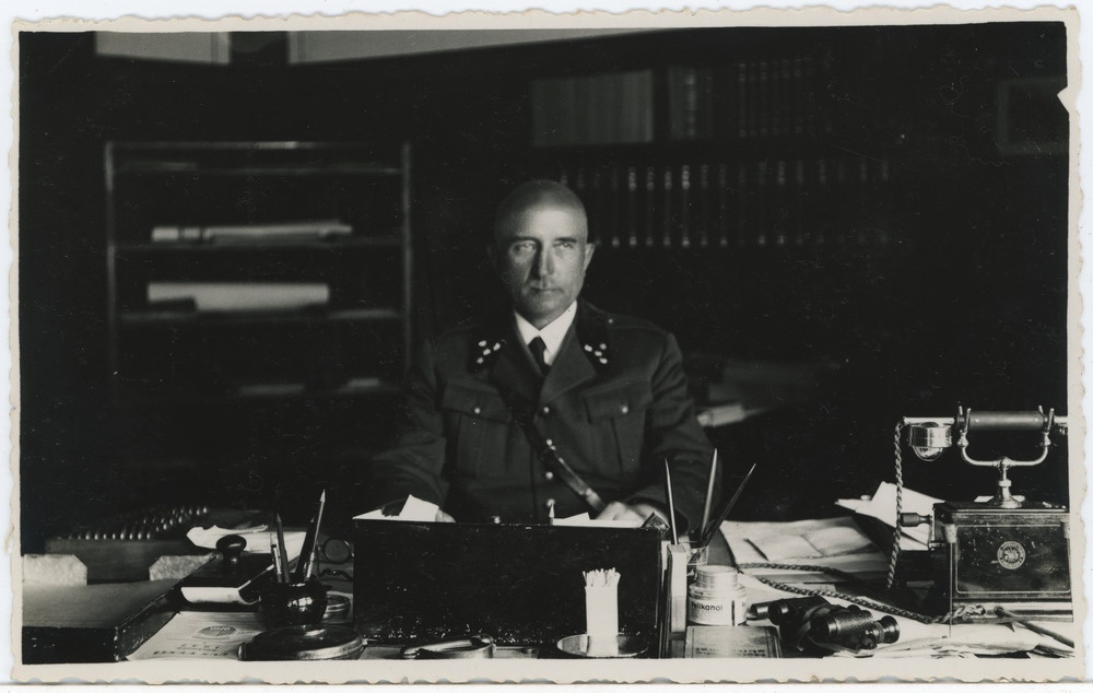 Metsnikuvormis meesterahvas laua taga istumas