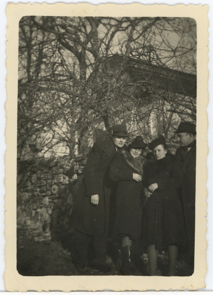 Kaks meest ja kaks naist müüri ja hoone taustal