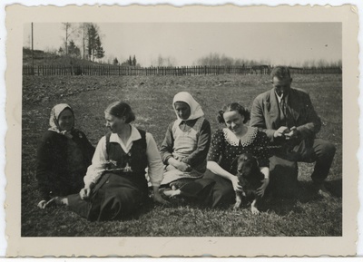 Grupp inimesi maastikul istumas, paremalt teine Salme Maling (Maimre, Ümarik) koos koeraga  duplicate photo