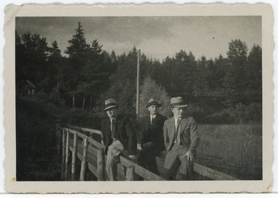 Kolm noormeest silla käsipuul istumas  duplicate photo