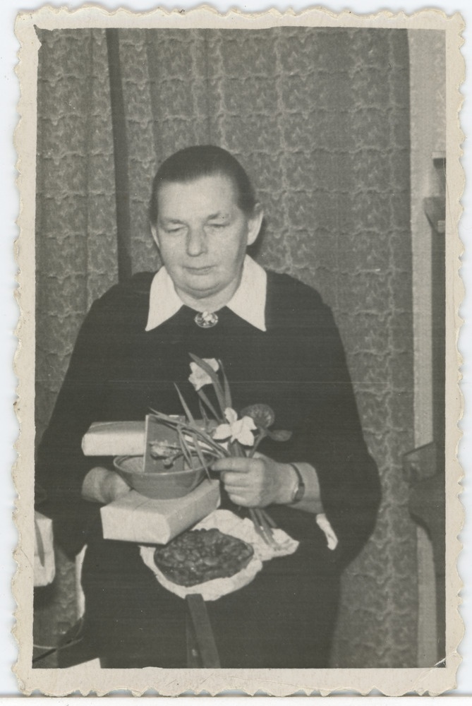 Marie Käär kingituste ja lilledega oma kodus