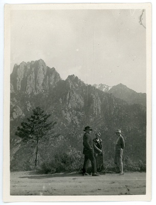 Johannes Vares, Emilie Vares ja Aurora Semper Korsikal seismas kaljude taustal ja vestlemas.  duplicate photo