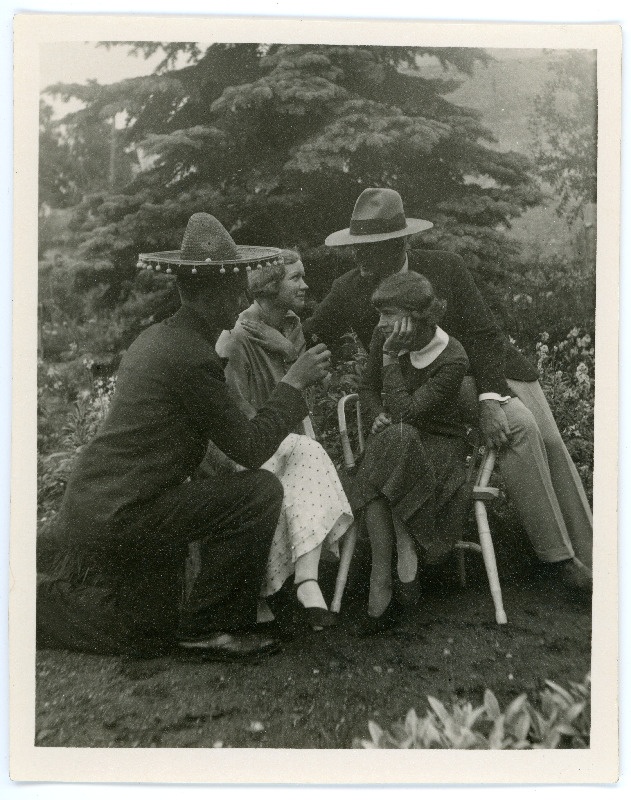 Johannes ja Emilie Vares sõpradega õuel. Naised istuvad toolidel, seljaga fotol olev meesterahvas põlvitab, sombreero peas, Johannes Vares toetub abikaasa toolile