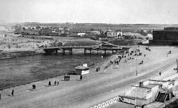 Emajõe paremkallas turuhoone ja endise Kivisilla vahelisel alal (endine Söögiturg); hiljem Oktoobri puiestee. Ees tribüün. Taga puusild Uueturu ja Holmi t hoonel. Tartu, ca 1947.