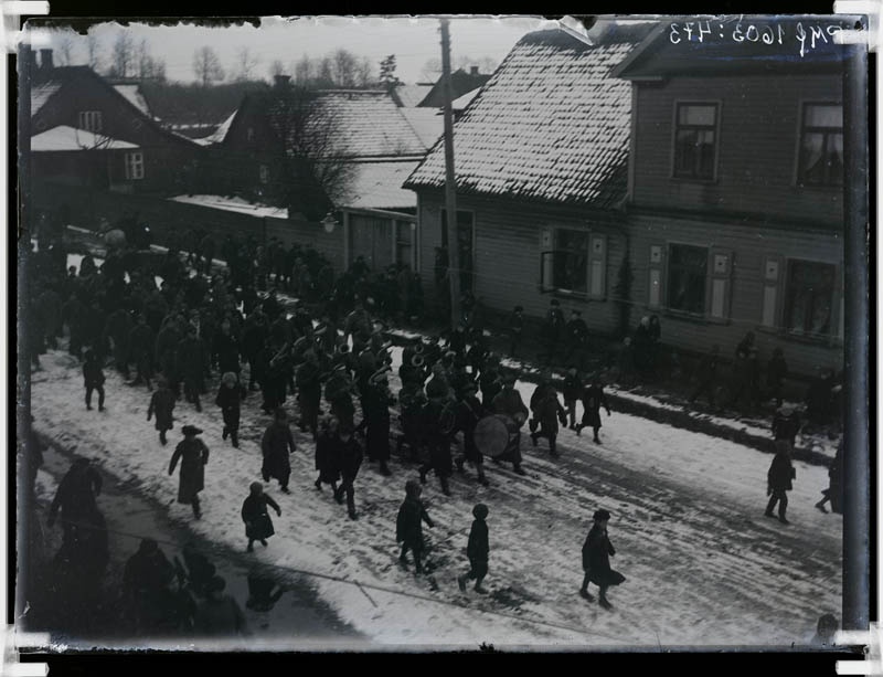 klaasnegatiiv, puhkpilliorkestriga sõjaväelased marsivad lumisel teel 1920.a.