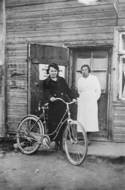 Kaks naist jalgrattaga juukselõikamise töökoja ees