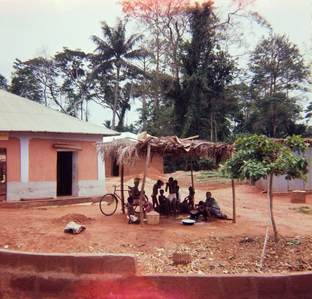 Rural women and children under the roof in the village of Dahomey (one. Benin); overview