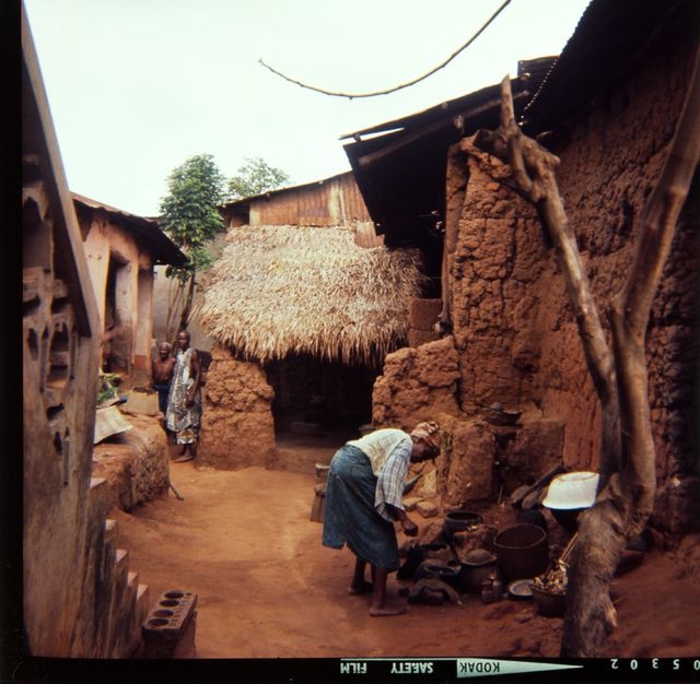 Gun-wife prepares food in the outdoor air kitchen between houses