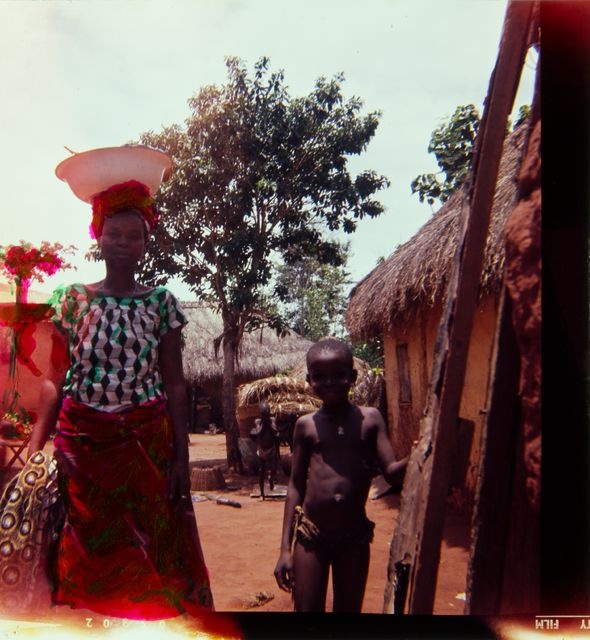 A woman carrying a baby on a village with a child; a personal photo