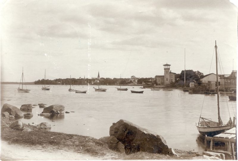 Foto. Haapsalu vaade Vanast sadamast  kaldaäärsetele rajatistele. Esiplaanil  paadisild ja purjekas. 20. saj algus.