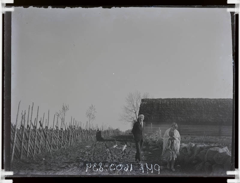 klaasnegatiiv, naine ja mees puithoone taustal, Lõõla 1920-30-ndad a.