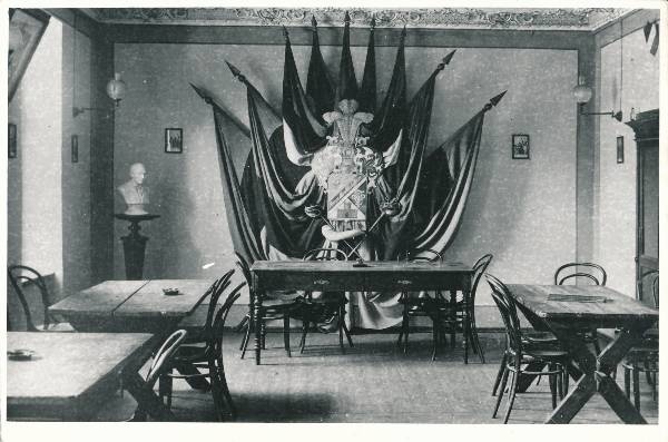 Korporatsiooni "Vironia" saal (puitmööbel, vapp seinal. Vapil deviis: "Ühisus. Kindlus. Ausus").
Tartu, 1920. aastad.