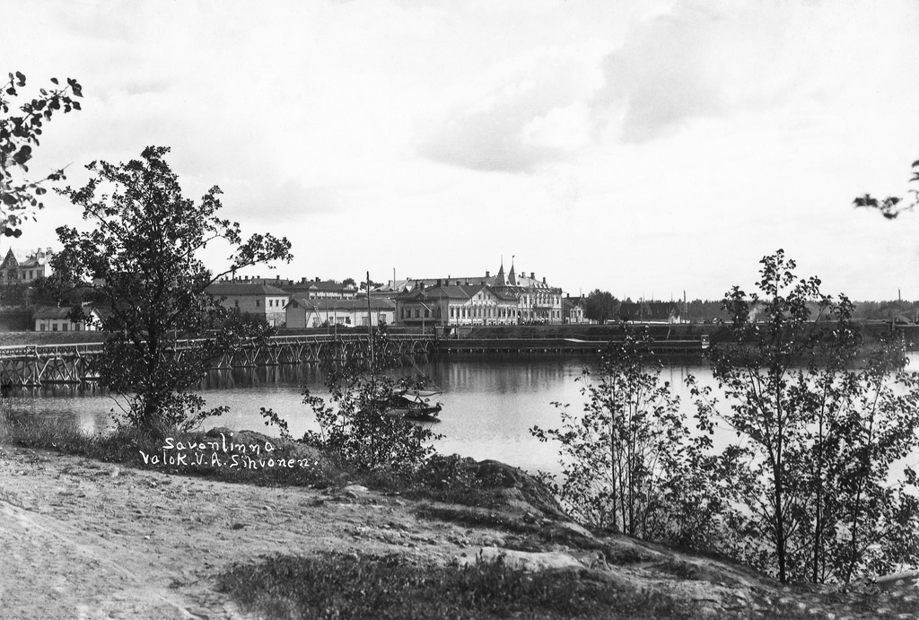 Näkymä Kasinonsaarelta Koululahden yli kaakkoon. Vasemmalla Kasinonsaaren silta. Koululahden etelärannalla Sikion talo ja taustalla Seurahuone. kesä 1908. View from Kasinonsaari over Koululahti to the southeast
