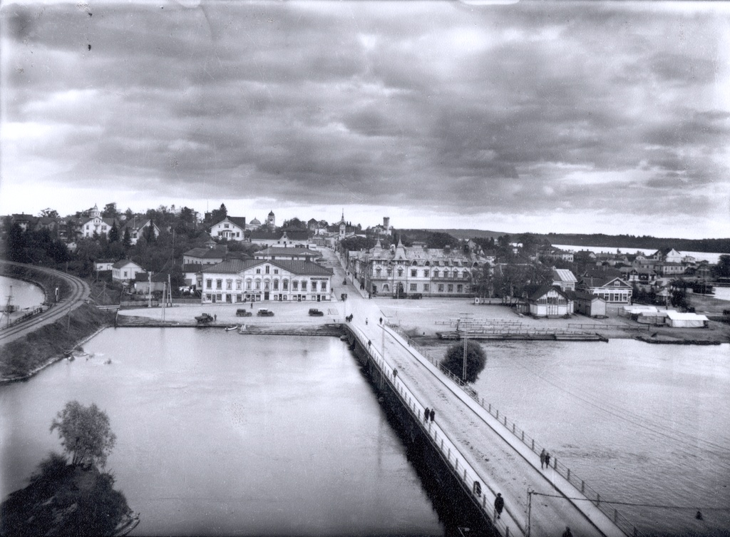 Näkymä Miljoonatalon yläkerrasta itään kohti I kaupunginosaa yli Haapasalmen. Vasemmalla rautatie, oikealla Linnankadun länsipää. Sikion talon ja Matkailijahotellin edessä autoja pirssissä. 1920-luku–1930-luku. View east from Miljoonatalo