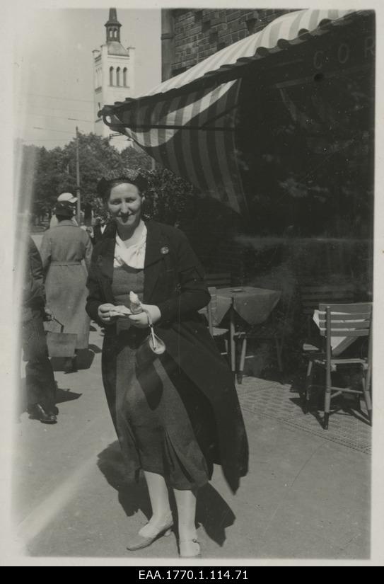 Women in Tallinn in front of the outdoor café, behind the tower of the Jaan Church