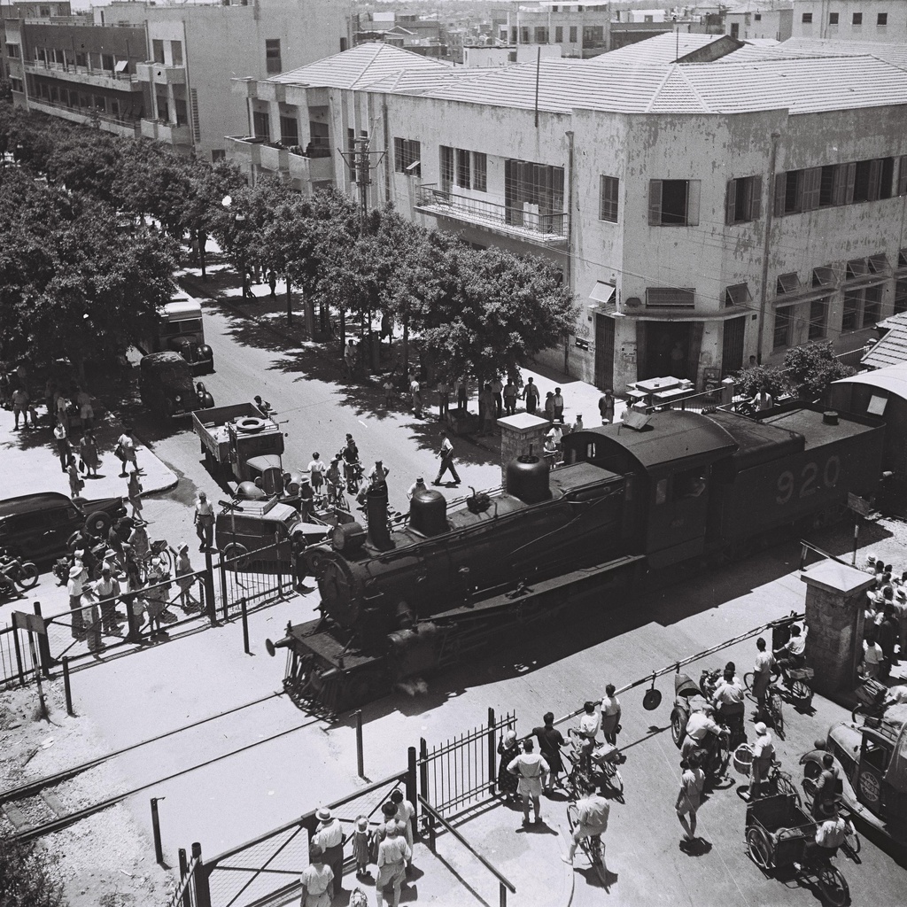 A LOCOMOTIVE CROSSING ALLENBY STREET IN TEL AVIV, NEAR THE MAIN POST OFFICE. קטר חוצה את רחוב אלנבי בתל אביב, ליד בניין הדואר המרכזי.D839-113
