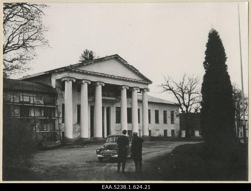 Kaks meest seljaga Raikküla mõisa peahoone esikülge taustal