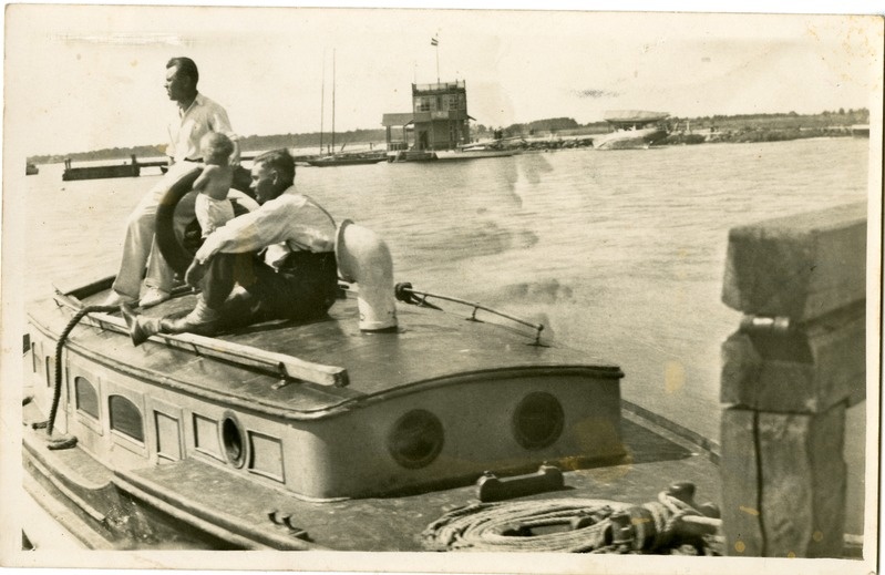 Kuressaare rand: esiplaanil jaht lapse ja kahe mehega, taamal saksa jahtklubi