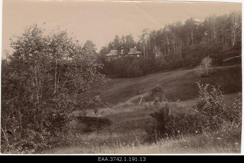 View of the wooden house behind the wooden belts on the hill floor of the grassland