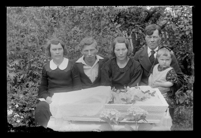 Lapse matused - perekond kirstu juures aias