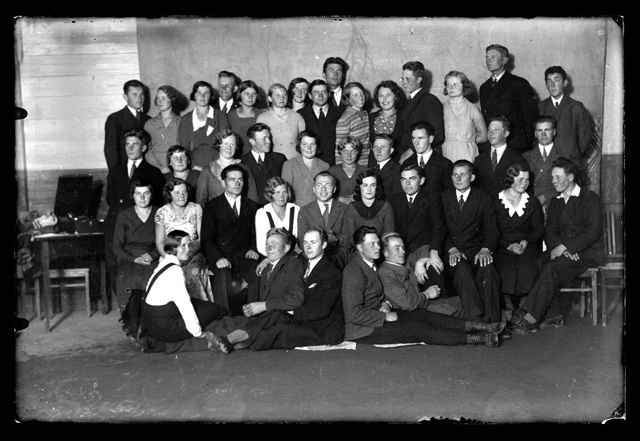 Grupipilt - pidulikes riietes noormehed ja neiud, taga grammofon