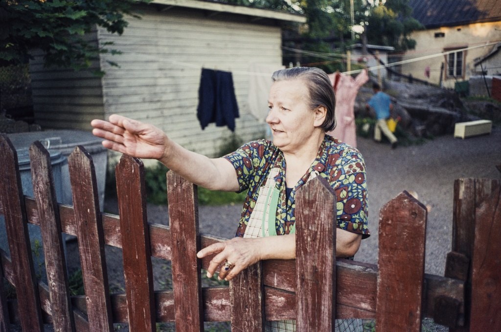 Nainen nojaamassa aitaan Puu-Pasilassa. 1970-luku.