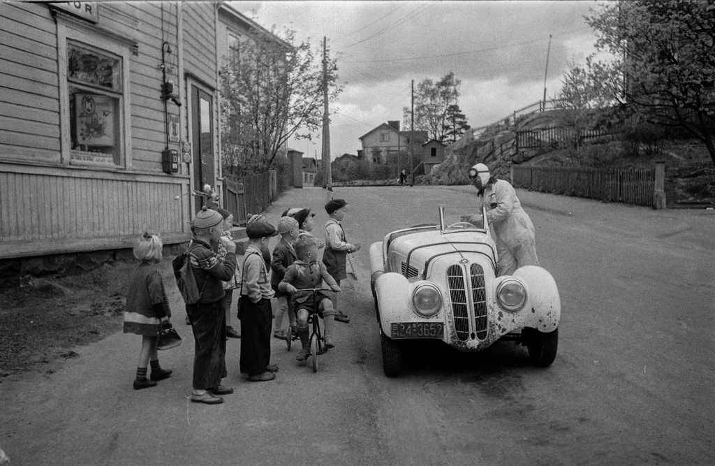 Pasila, Hertankatu 18, tontin alatalo, lapsia ihmettelemässä kauppias ja kilpa-ajaja Leo I. Mattilan BMW-merkkistä kilpa-autoa tämän kaupan edessä.