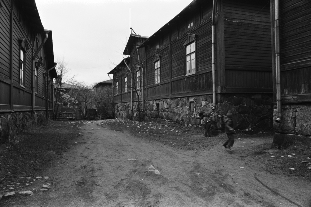 Lastenkodinkatu 2-10. Lapsi hyppäämässä narua Ruoholahden sadan markan villojen syksyisessä pihapiirissä.
