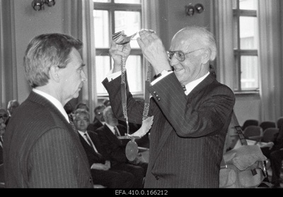 At the inauguration of Rector of Tallinn University of Pedagogy Mait Arvisto, the President of the Republic of Estonia, Lennart Meri, puts his office on his neck.  similar photo