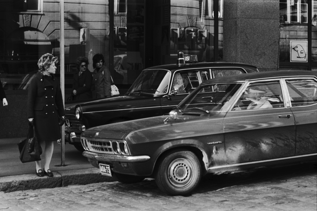 Jalankulkijoita sekä jalkakäytävällä oleva poliisiauto Eerikinkadulla Fredrikinkadun kulmassa