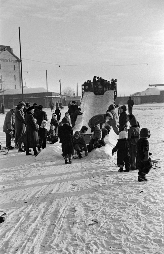 Jäämäki ja lapsia laskemassa mäkeä Hakaniementorin kaakkoiskulmassa