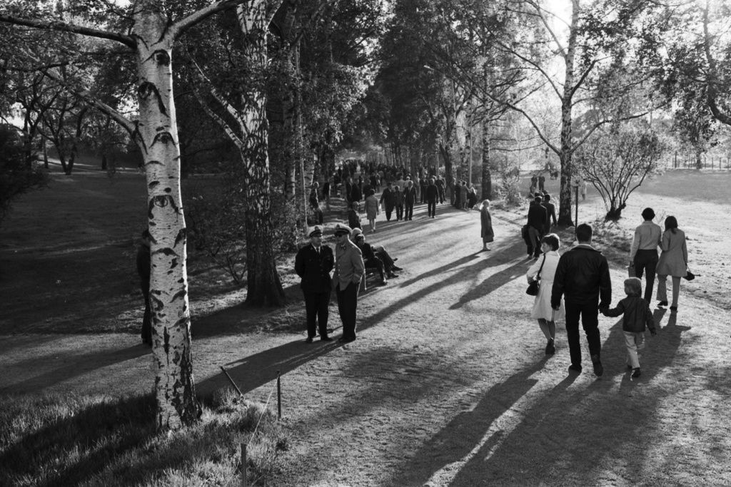 Kaisaniemenpuisto. Ihmisiä ilta-auringossa Kaisaniemenpuiston puistokäytävällä ennen Vietnamin sodan vastaisen mielenosoituksen alkua.