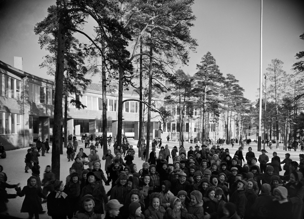 Lapsia uuden Meilahden kansakoulun pihalla. Rakennuksen olivat suunnitelleet arkkitehdit Osmo Sipari ja Viljo Revell (ko kohteen arkkitehtikilpailun voittajat), kaarevarunkoinen koulu rakennettiin vuosina 1949-1953.