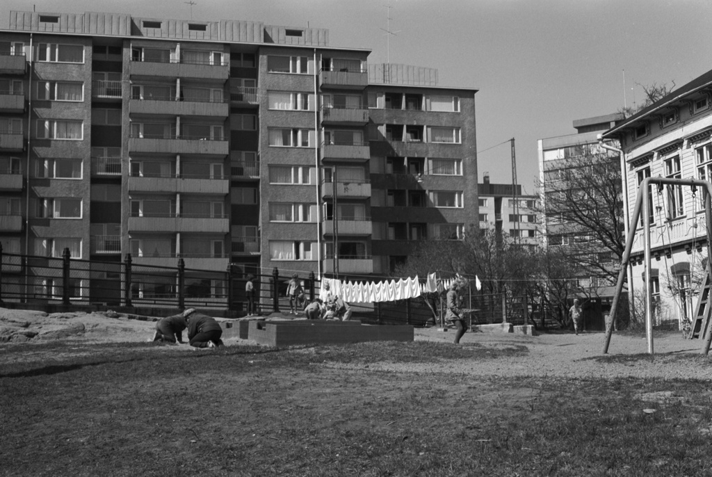 Siltasaarenkatu 13. Porthaninkatu 2. Porthaninkadun ja Siltasaarenkadun kulmassa sijaitsevan Tukholman päiväkodin pihapiiriä, jossa lapsia leikkimässä ja pyykkiä narulla kuivumassa.
