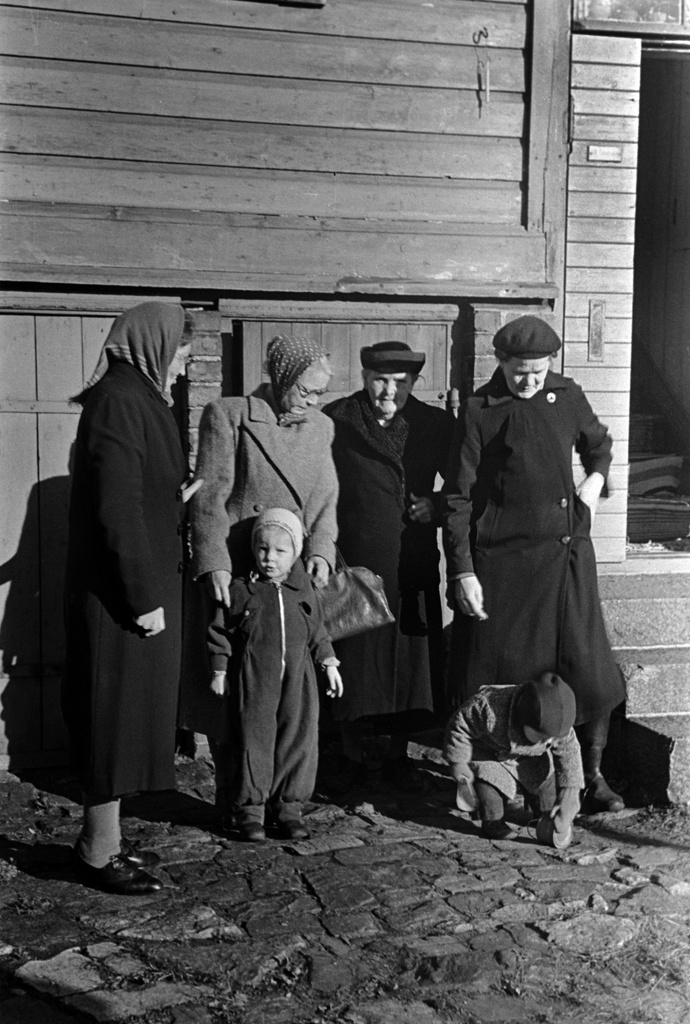 Lastenkodinkatu 2-10. Ryhmä iäkkäämpiä naisia ja kaksi lasta puurakennuksen edessä, todennäköisesti ns