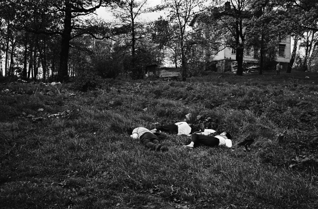 Tokoinranta. Nurmikolla nukkuvia (sammuneita) miehiä makaamassa Tokoinrannassa. Taustalla puiden katveessa Eläintarhan huvila 14.