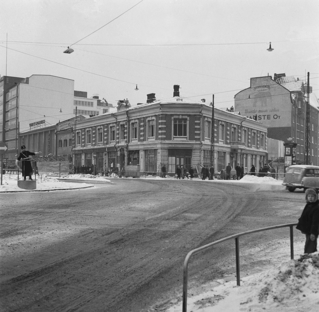 Siltasaarenkatu 16. Taustalla näkyy seinään maalattu Mauste Oy:n mainos. Vasemmalla liikennepoliisi korokkeellaan.