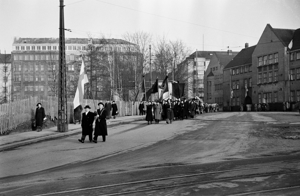 Miina Sillanpään hautajaiset. Hautasaatto kääntymässä Kalmistokadulle (=Mechelininkatu), taustalla Eteläinen Rautatiekatu 20, oikealla Marian sairaala.