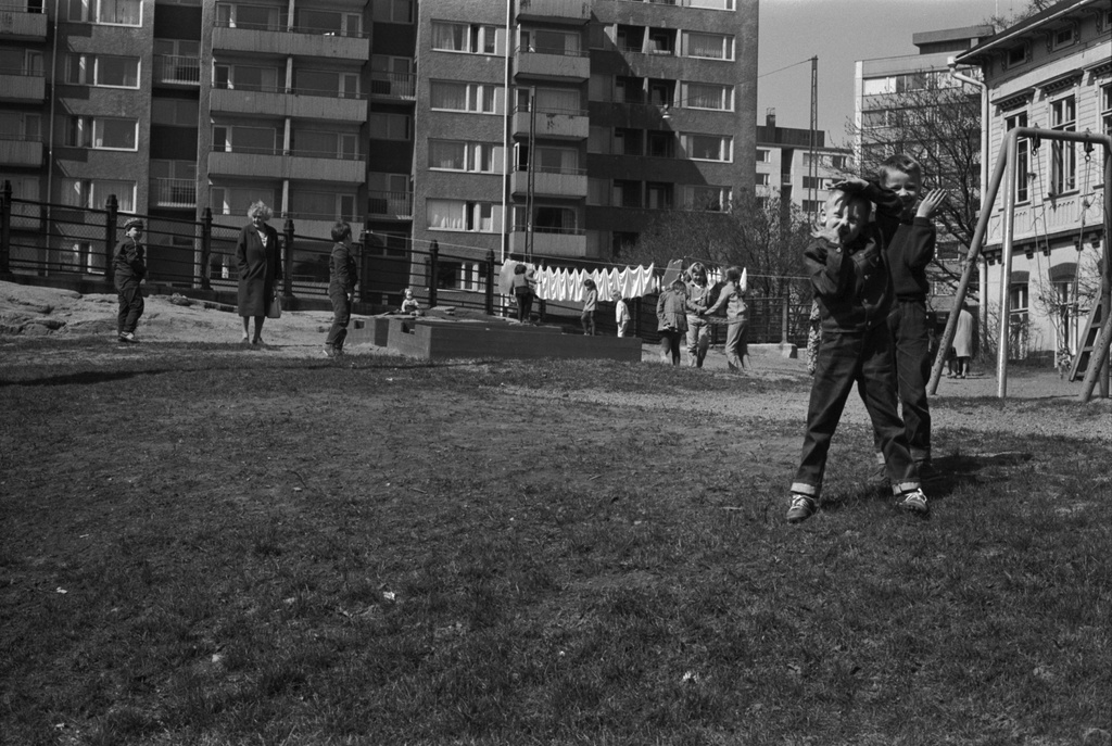 Siltasaarenkatu 13. Porthaninkatu 2. Porthaninkadun ja Siltasaarenkadun kulmassa sijaitseva Tukholman päiväkodin pihapiiriä, jossa lapsia leikkimässä ja pyykkiä narulla kuivumassa.