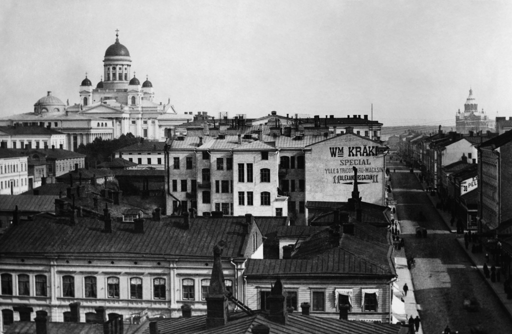 Aleksanterinkatu 13, 11, etualalla Mikonkatu 5.  Taustalla vasemmalla Nikolainkirkko (= Helsingin tuomiokirkko) ja oikealla  Uspenskin katedraali Katajanokalla.