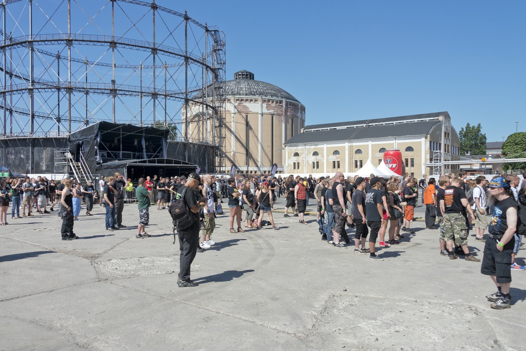 Metallimusiikkifani. Tuska-festivaalin päälavan yleisöä. Vasemmalla on Suvilahden entisellä energiantuotantoalueella jäljellä olevat, käytöstä poistetut kaasukellot, joita käytettiin kaasuvarastoina.