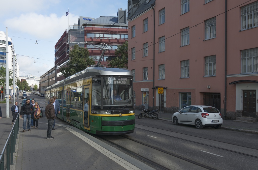 Fleminginkatu 26. Ihmisiä Fleminginkadun raitiovaunupysäkillä
