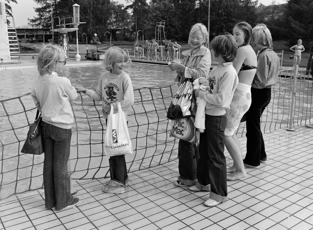 Tyttöjä seisomassa altaan reunalla uimastadionilla.