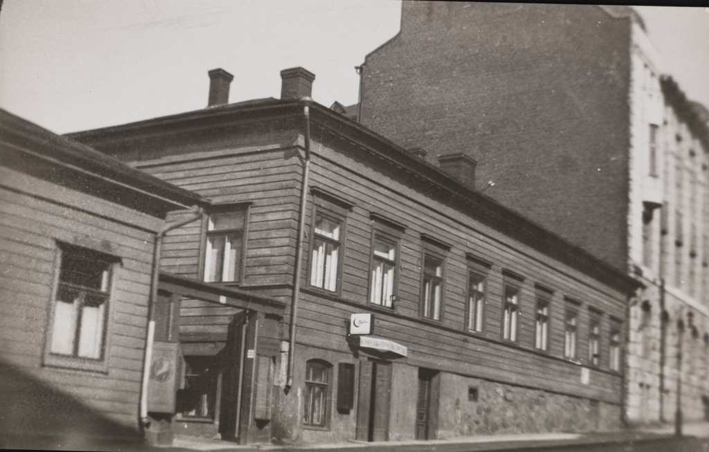 Fabianinkatu 24. Tämä rakennus purettiin 1920-luvun lopulla ja sen tilalle rakennettiin vuosina 1927-1931 Helsingin yliopiston hammaslääketieteen laitoksen rakennus. Puutalon takana näkyvä kivinen kerrostalo oltiin rakennettu Fabianinkatu 26:een vuonna 1907.