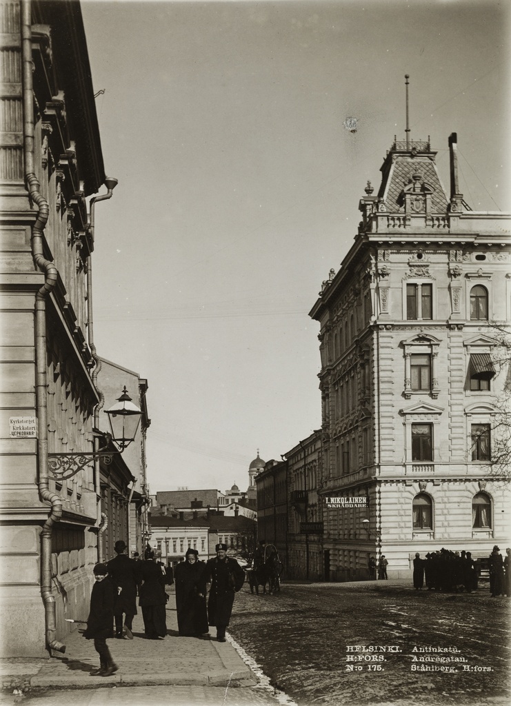 Jalankulkijoita Antinkadulla (nykyinen Lönnrotinkatu), oikeassa reunassa rakennus osoitteessa Antinkatu 4 - Yrjönkatu 13, valmistunut 1890.