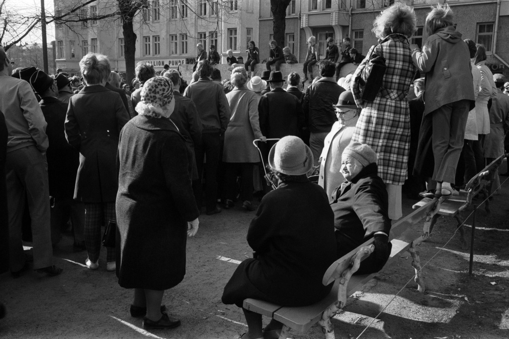 Karhupuisto. Helsingin juhlaviikot. Yleisöä seuraamassa esitystä Karhupuistossa puistotapahtuman aikaan. Etualalla tyttöjä seisomassa penkin selkänojalla nähdäkseen paremmin. Taustalla lapsia näyttämön taustafondinn päällä.