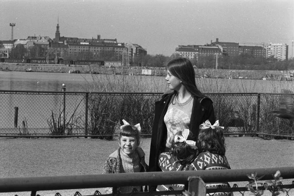Tokoinranta. Nuori nainen ja kolme rusettipäistä lasta Eläintarhantien ja Säästöpankinrannan kulmauksessa olevassa puistossa.