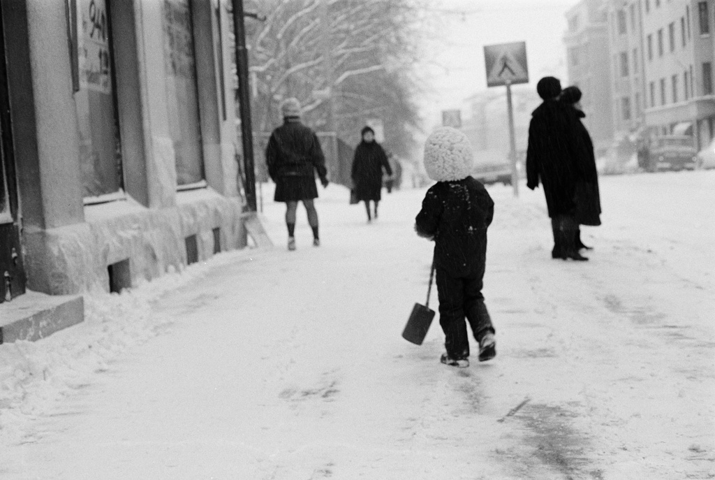 Ensilumi Töölössä vuonna 1973. Katunäkymä Arkadiankatu 15 edustalta. Lumitöitä ja jalankulkijoita. Vasemmalla alkaa Aurorankatu, jonka yli suojatie kulkee. Kauempana taka-alalla Luonnontieteellinen museo.