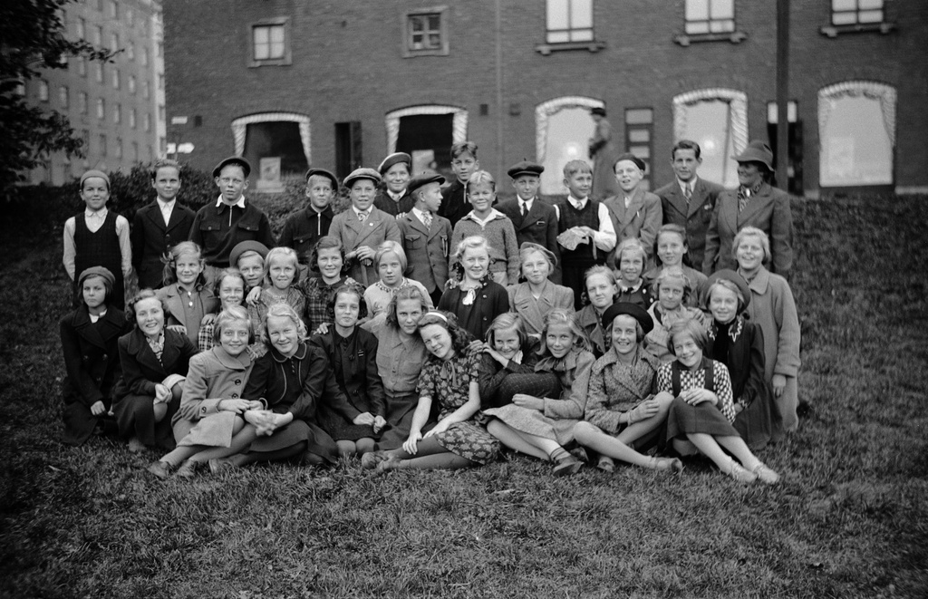 Oppilaita ja opettaja luokkakuvassa Haapaniemen kentän (=Väinö Tannerin kenttä) laidalla